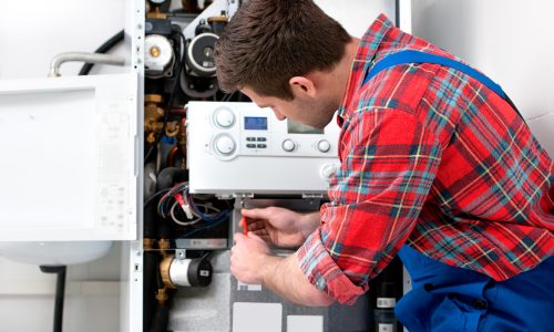 Technician servicing the gas boiler for hot water and heating